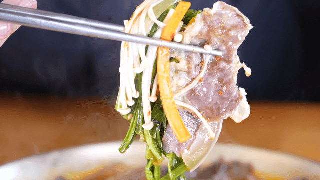 Chopsticks holding stew with vegetables and beef