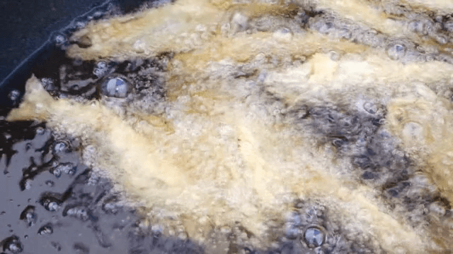 Fish frying in hot oil in a pan