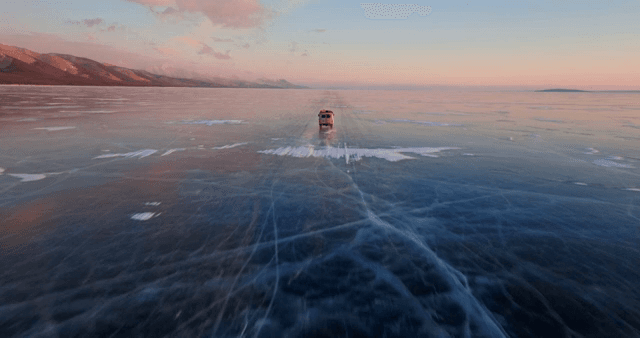 해질녘 얼어붙은 호수를 달리는 차량