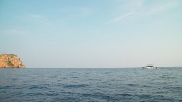 Calm sea with a distant ship in the afternoon