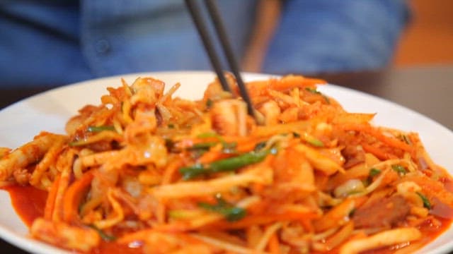 Chopstickful of spicy stir-fried Jjamppong with plenty of squid and vegetables