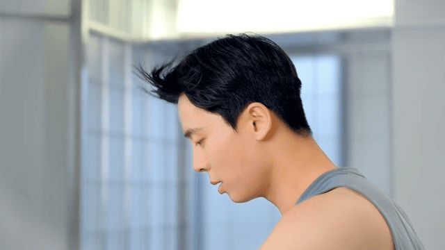 Side view of a man focused on exercise as his hair moves