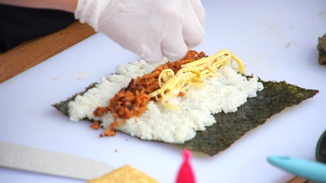 Preparing kimbap with rice and fillings