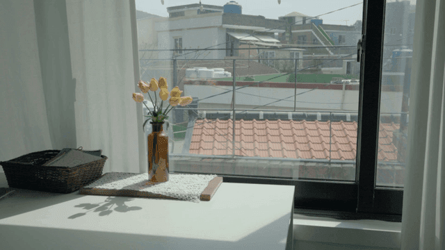 Vase of yellow tulips on windowsill1