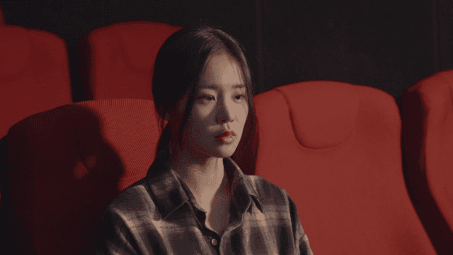 극장 좌석에 앉아 감상에 젖은 여성