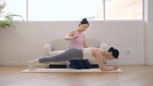 Yoga instructor guiding a student indoors