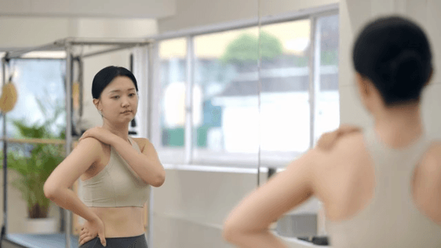 Woman checking her body while looking in the mirror