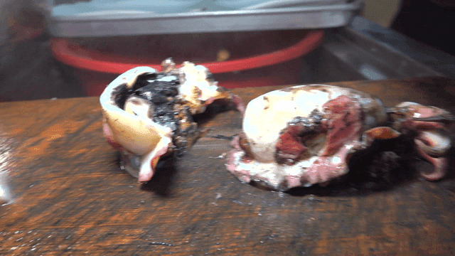 Boiled squid being sliced ​​on cutting board