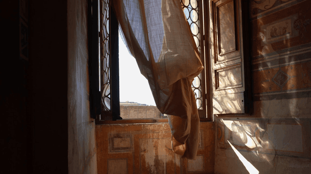 Curtain blowing in the breeze by a window