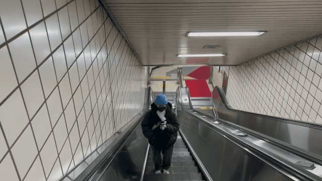 지하철역 에스컬레이터에 있는 사람