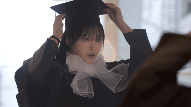 Graduate looking in mirror and adjusting his mortarboard