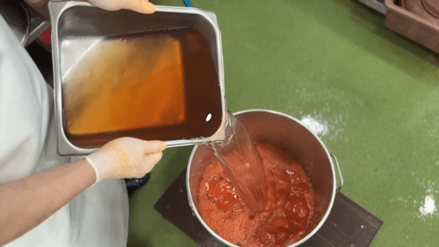 빨간 혼합물에 액체를 붓는 장면