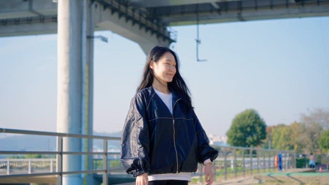 Woman stretching under a bridge outdoors