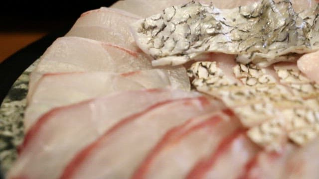 신선한 회 조각을 초장 소스에 찍어 먹는 모습