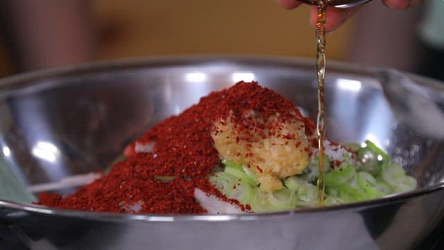 무생채를 만들기 위해 액젓을 추가하는 모습