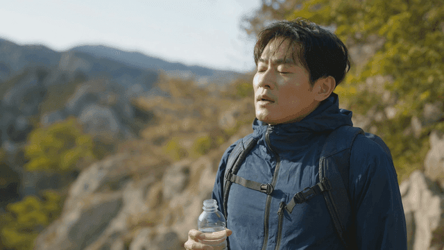 Man drinking water while hiking in mountains