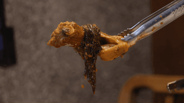 집게로 들어 올린 매운 갓김치 등갈비찜