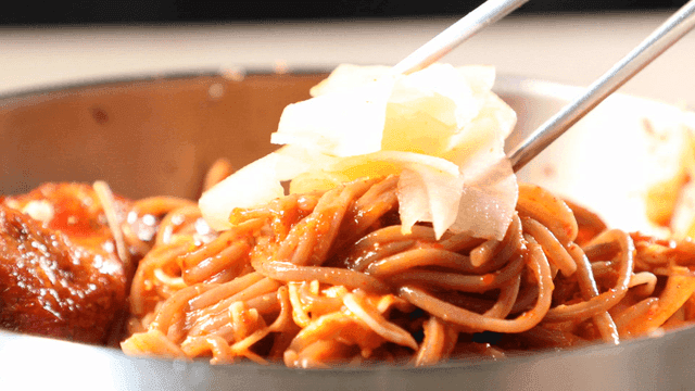 Bibim-guksu with spicy sauce and pickled radish