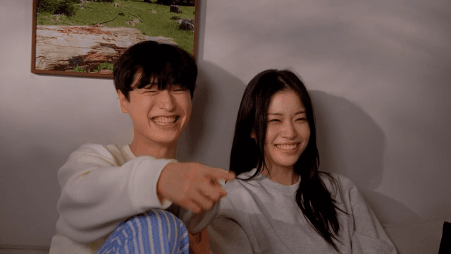 소파에서 팝콘을 먹으며 코믹 영화 보며 웃는 커플