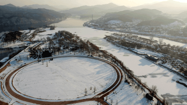 Snow-covered park with a frozen river