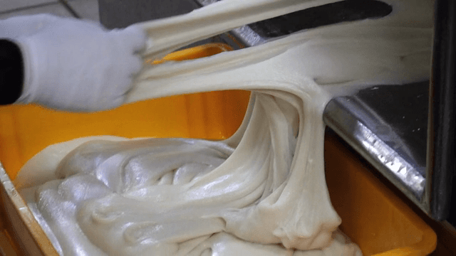 기계에서 떡 반죽을 꺼내는 작업자