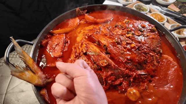 Spicy braised duckfish simmering in pot and fist