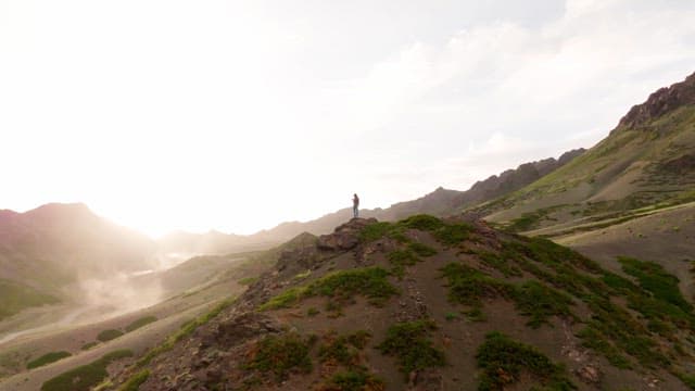 Person standing on a mountain in the sunlight