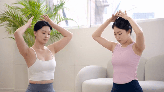 Two women stretching indoors