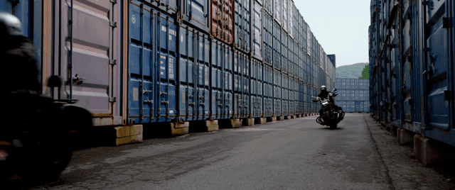 컨테이너 사이를 달리는 오토바이