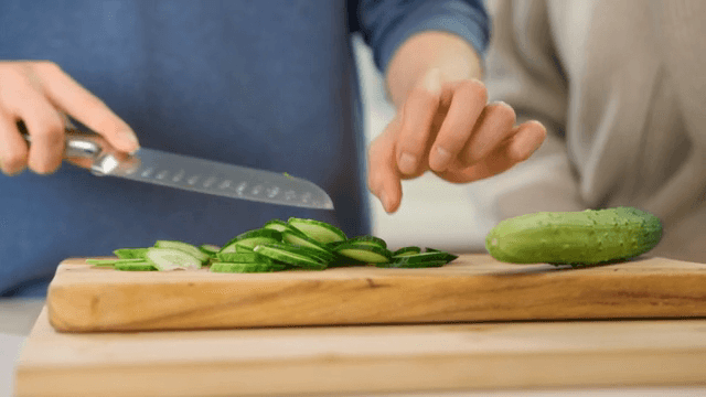 나무 도마 위에서 자르는 신선한 오이