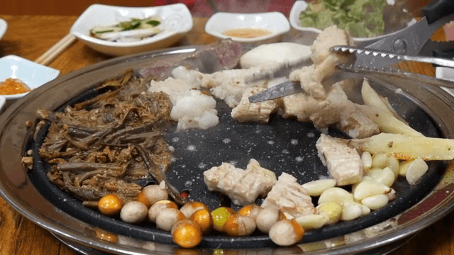 Various cuts of tripe grilled on a hot iron plate