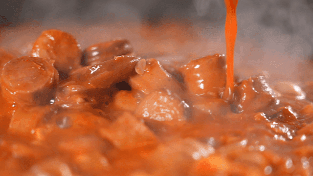 Spicy budaejjigae  filled with sausages as rich broth is poured