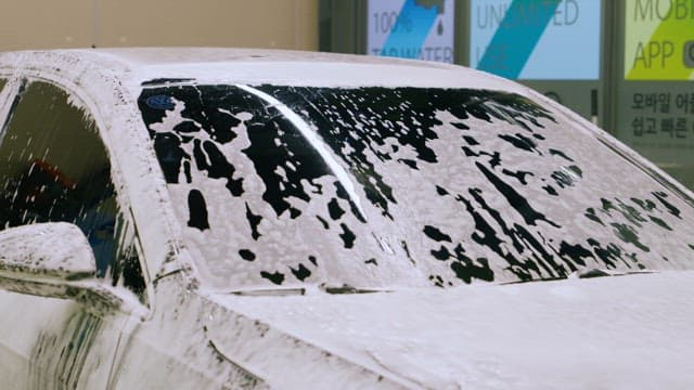 Washing Foam Off Car Windshield with a Water Hose