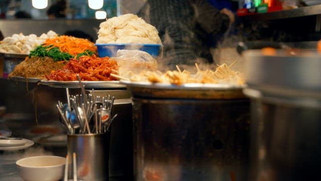 Busy Gwangjang Market street food stalls with steaming dishes