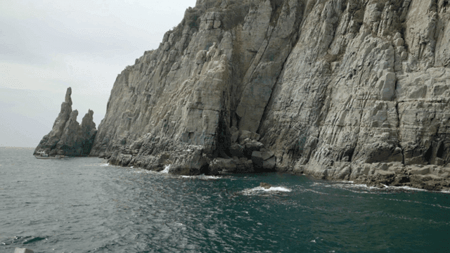 Rocky cliffs by the sea with gentle waves