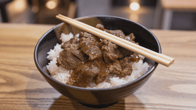 Beef gyudon rice bowl with chopsticks