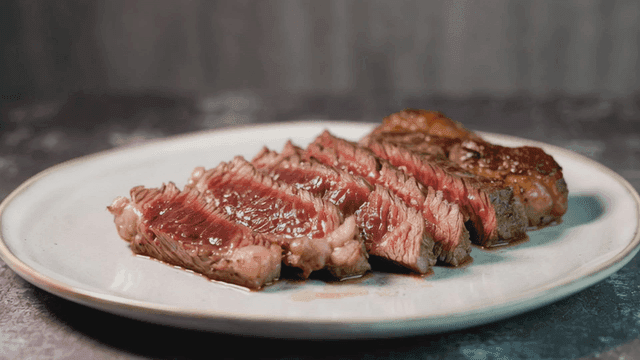 Juicy sliced steak on a white plate