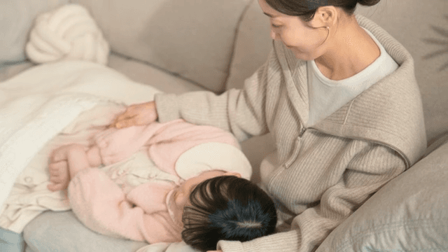 Mother gently caressing her sleeping baby