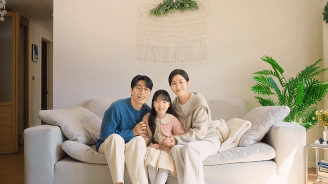 사진을 찍기 위해 소파에 함께 앉아 포즈를 취하는 가족