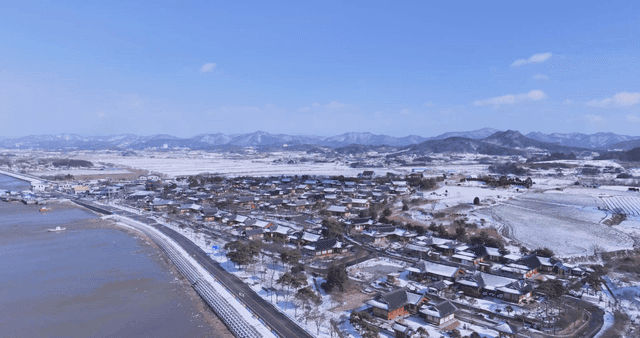 Snow-covered traditional Hanok village on riverside