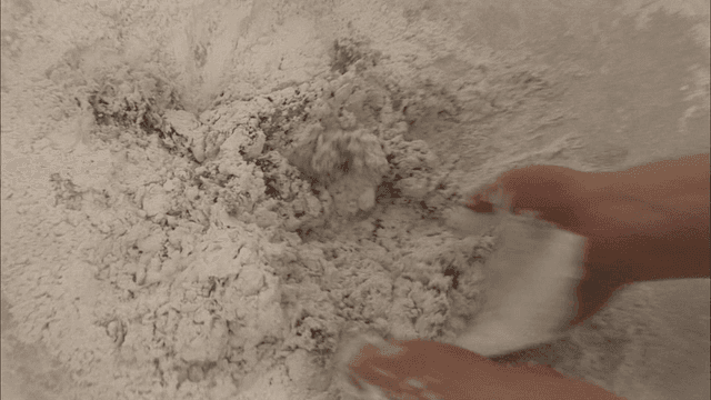 큰 그릇에서 반죽을 치대는 손