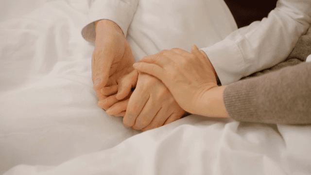 침대 위에서 서로 손을 잡고 있는 모습