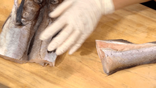 나무 도마 위에서 잘리는 명태