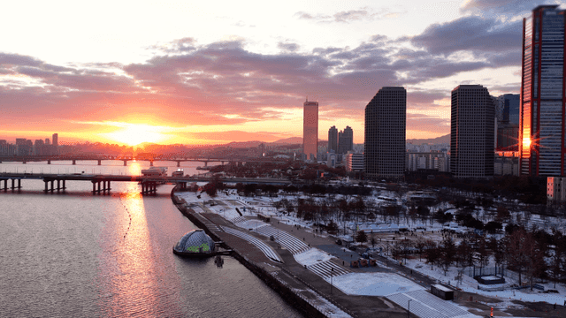 Sunset over a snowy urban riverside