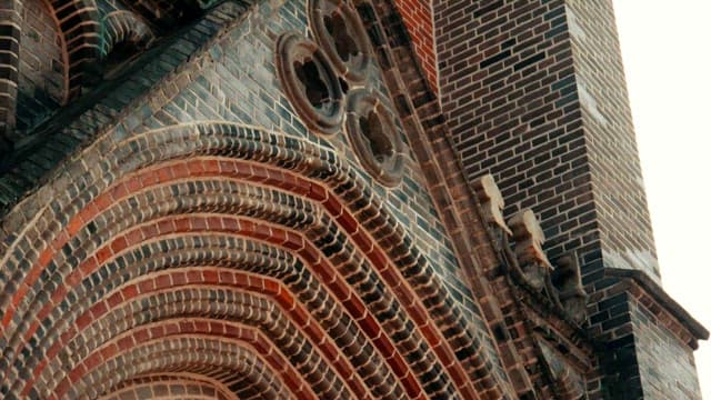 정교한 아치와 트레포일이 있는 고딕 양식의 벽돌 성당탑