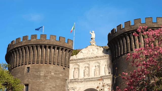 Historic castle with flags and statue