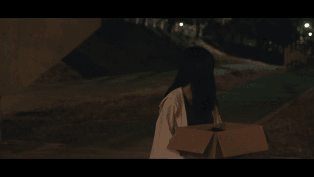 밤에 상자를 들고 서 있는 여성