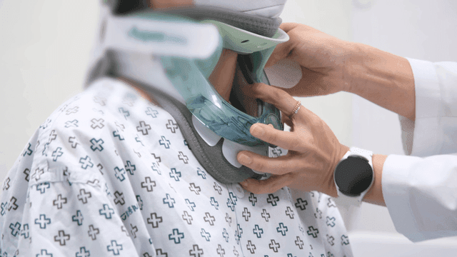 Doctor adjusting a neck brace for a patient