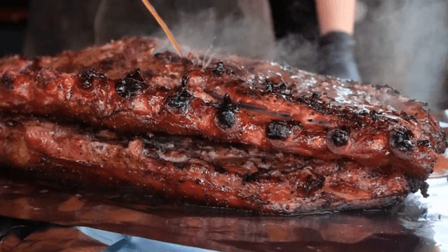 Juicy grilled ribs being basted