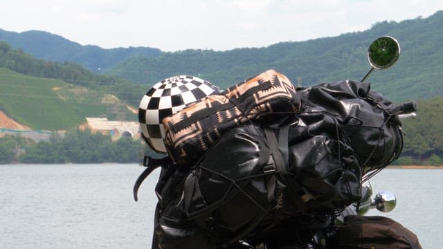 Motorcycle set against a backdrop of blue mountains and lakes